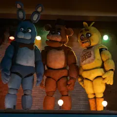 Trzej animatronicy z filmu FNAF: Bonnie, Freddy i Chica stoją na scenie.