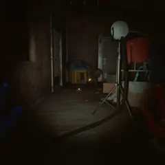 Ręce gracza w grze Poppy Playtime Chapter 5, w mrocznym korytarzu fabryki zabawek.