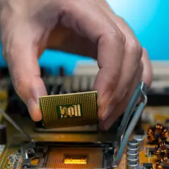 Dłoń montuje procesor zintegrowany z grafiką Intel UHD do płyty głównej.