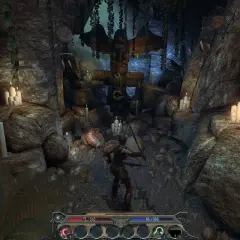Postać w jaskini z totemicznym posągiem i świecami. Klimat z gry Divinity II: Ego Draconis.