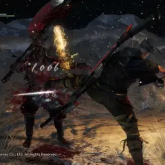 Intensywna walka w Nioh 2. Wojownik w czerwonej zbroi otrzymuje cios, z jego ciała tryska krew.