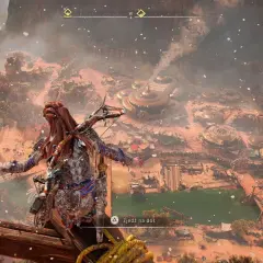Aloy z Horizon Zero Dawn 2 spogląda na osadę z góry. W tle widać górzysty krajobraz i mgłę.