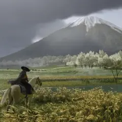 Jazda konna w Ghost of Tsushima PC. W oddali widać ośnieżony szczyt góry, a na pierwszym planie kwitnące drzewa i rzekę.