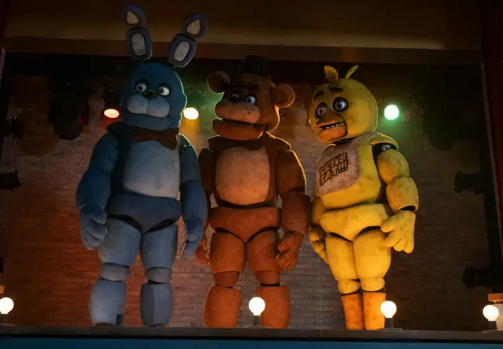Trzej animatronicy z filmu FNAF: Bonnie, Freddy i Chica stoją na scenie.