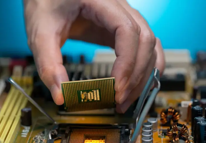 Dłoń montuje procesor zintegrowany z grafiką Intel UHD do płyty głównej.