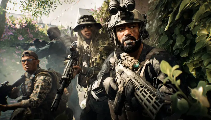 Żołnierze w kamuflażu, gotowi do akcji w kampanii Battlefield 6. W tle kwitnące krzewy i zieleń.
