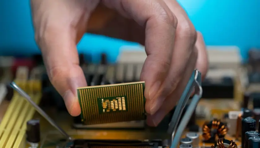 Dłoń montuje procesor zintegrowany z grafiką Intel UHD do płyty głównej.