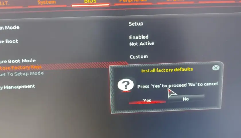 Ekran BIOS z opcją "Restore Factory Keys" do wyłączenia Secure Boot. Potwierdź "Yes", aby przywrócić ustawienia fabryczne.