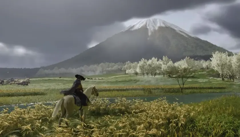 Jazda konna w Ghost of Tsushima PC. W oddali widać ośnieżony szczyt góry, a na pierwszym planie kwitnące drzewa i rzekę.