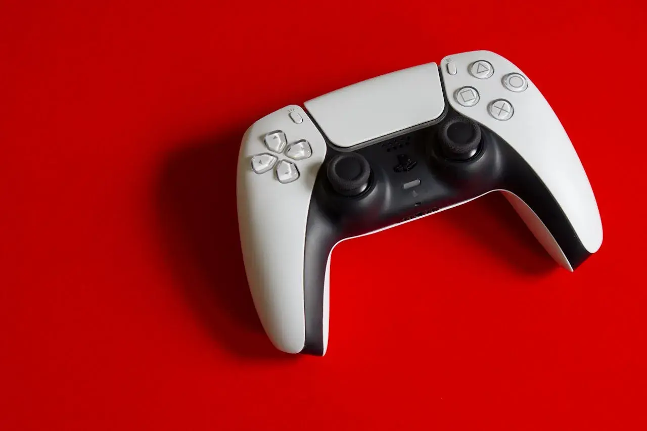 Biały kontroler DualSense na czerwonym tle. Idealny do gier na PS5, a dzięki DS4Windows sprawdzi się też na PC.