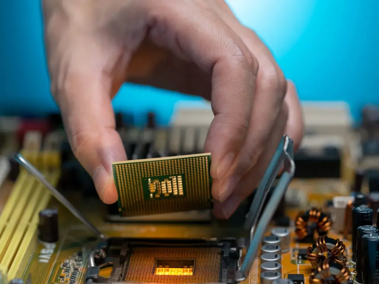 Dłoń montuje procesor zintegrowany z grafiką Intel UHD do płyty głównej.