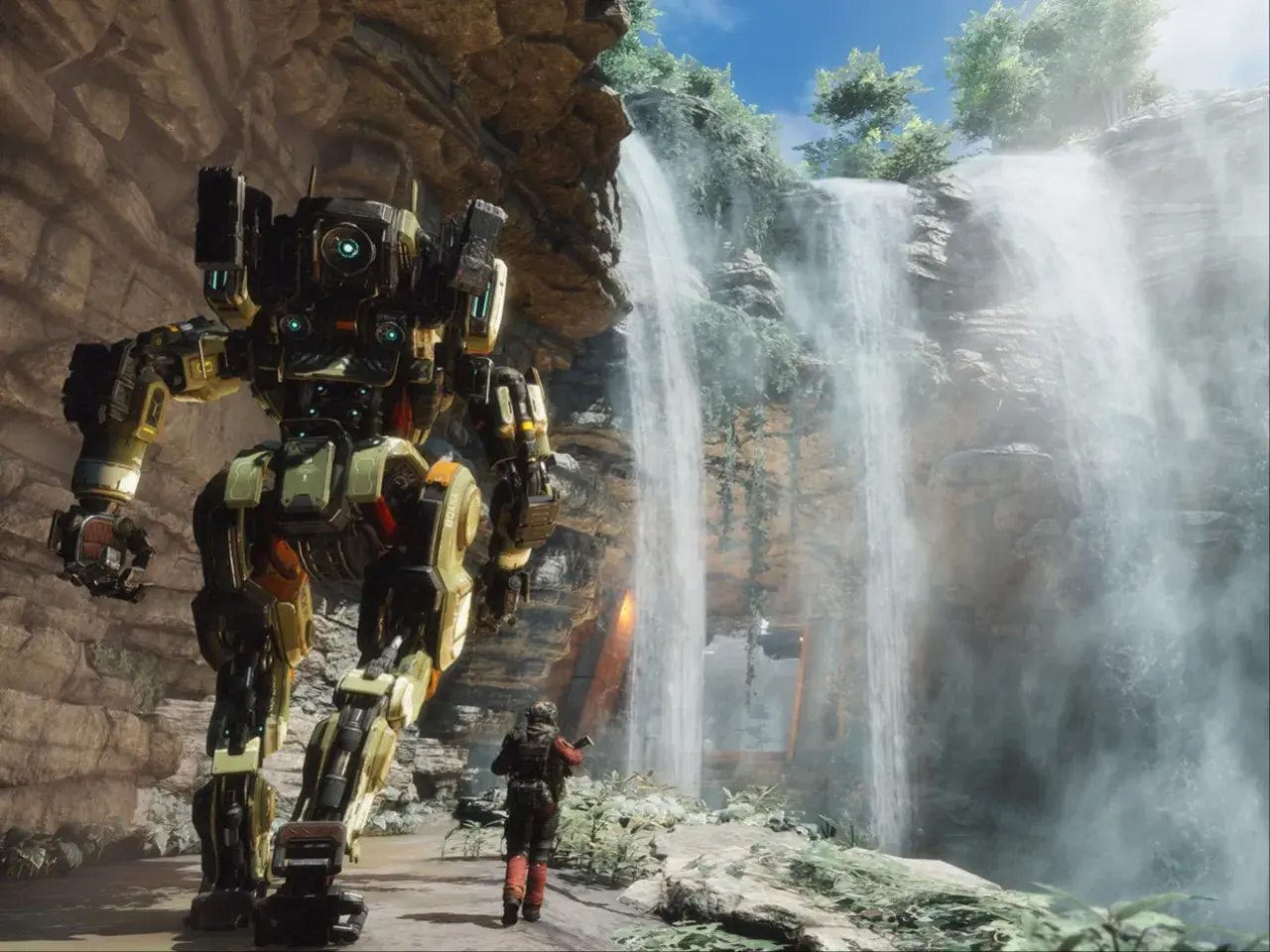 Potężny mech z gry Titanfall 3 stoi obok wodospadu, a pilot w skafandrze bojowym obserwuje go.