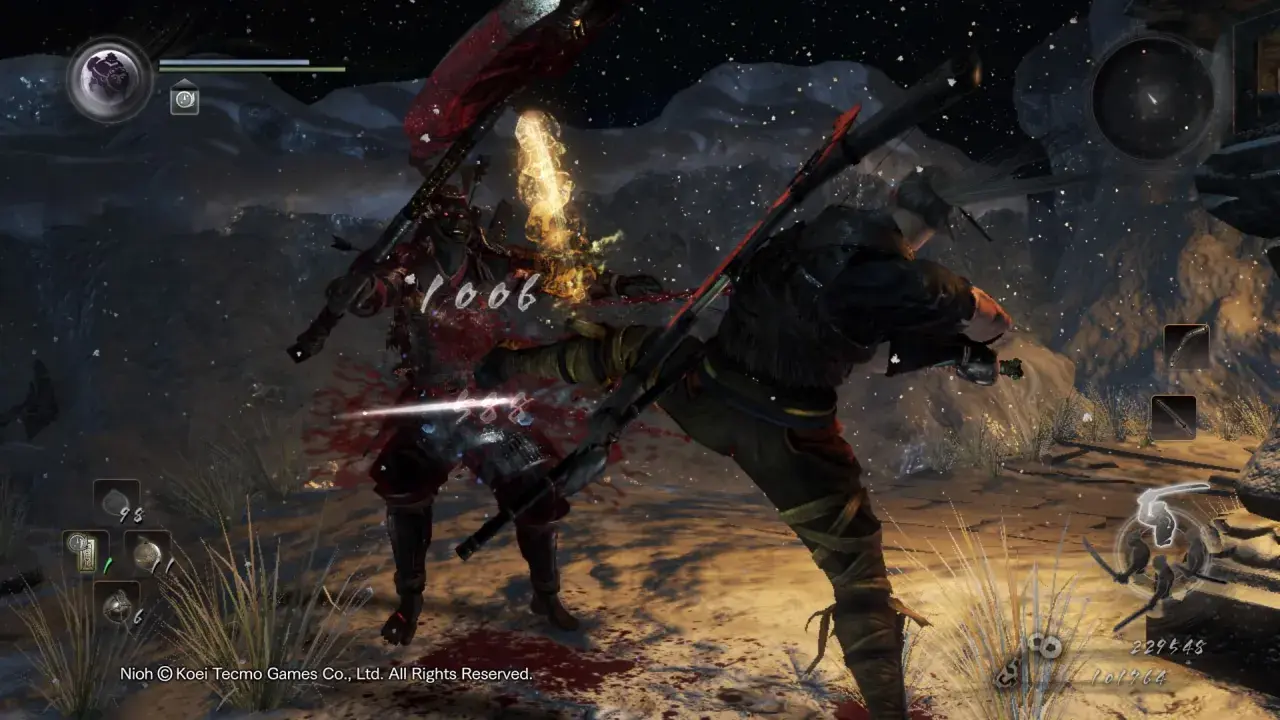 Intensywna walka w Nioh 2. Wojownik w czerwonej zbroi otrzymuje cios, z jego ciała tryska krew.