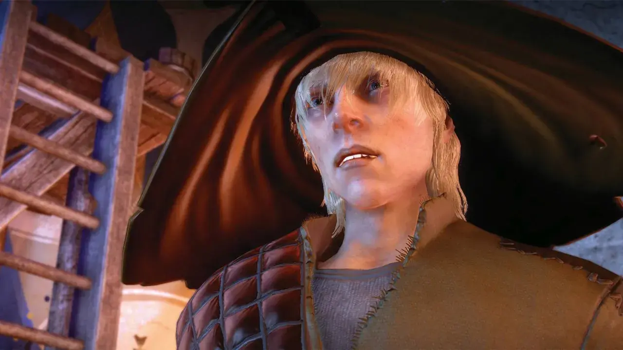 Cole z Dragon Age w swoim charakterystycznym stroju, z blond włosami i niebieskimi oczami, spogląda w górę.
