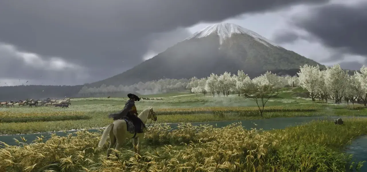Jazda konna w Ghost of Tsushima PC. W oddali widać ośnieżony szczyt góry, a na pierwszym planie kwitnące drzewa i rzekę.