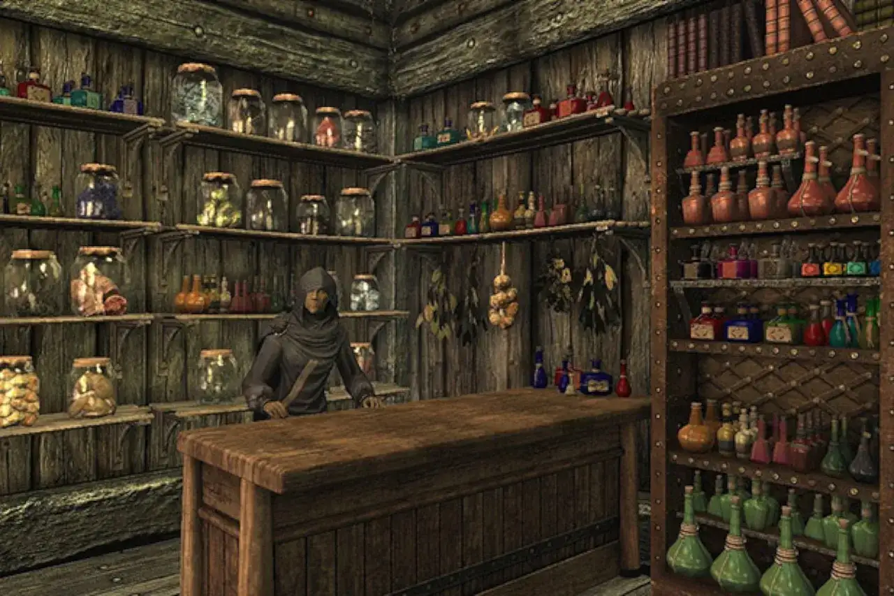 Postać w kapturze za ladą sklepu alchemicznego w Skyrim. Półki uginają się od słoików z ziołami i buteleczek z eliksirami, idealnych do tworzenia własnych skyrim alchemia przepisy.