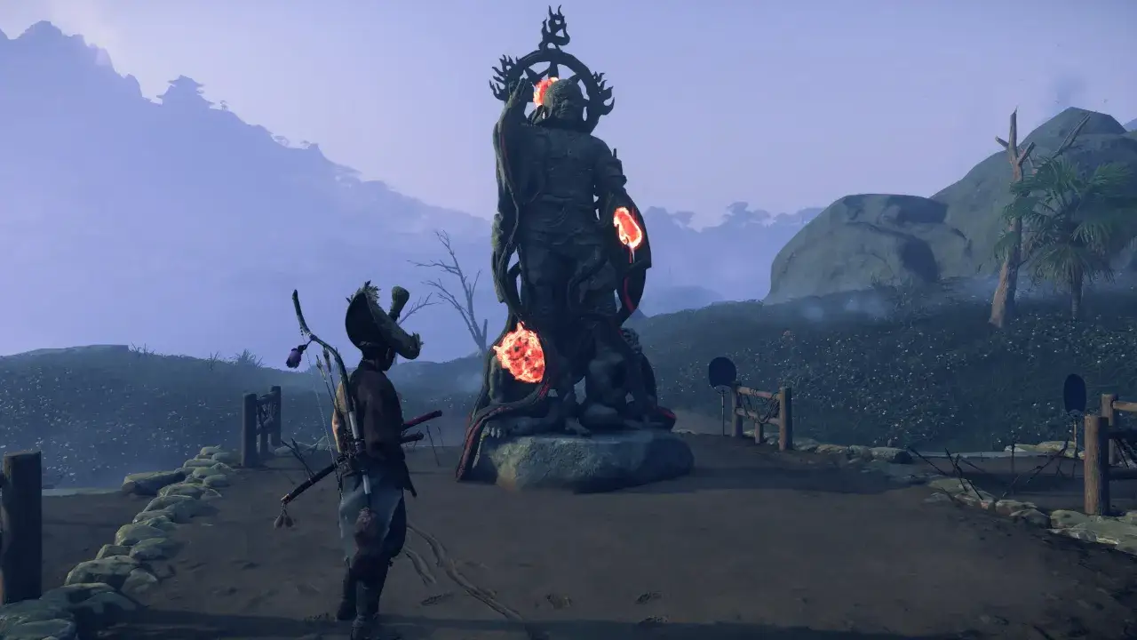 Samuraj przed zakazaną kapliczką w Ghost of Tsushima. Kamienna rzeźba z płonącymi detalami w mglistym krajobrazie.