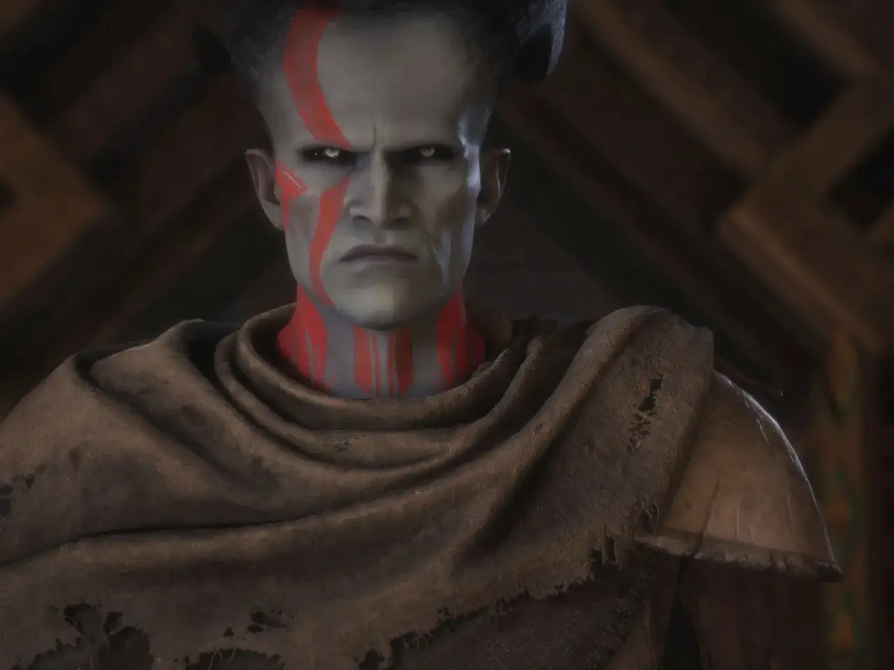 Surowy qunari z Dragon Age, z czerwonymi malowidłami wojennymi na twarzy i szyi, spogląda z determinacją.
