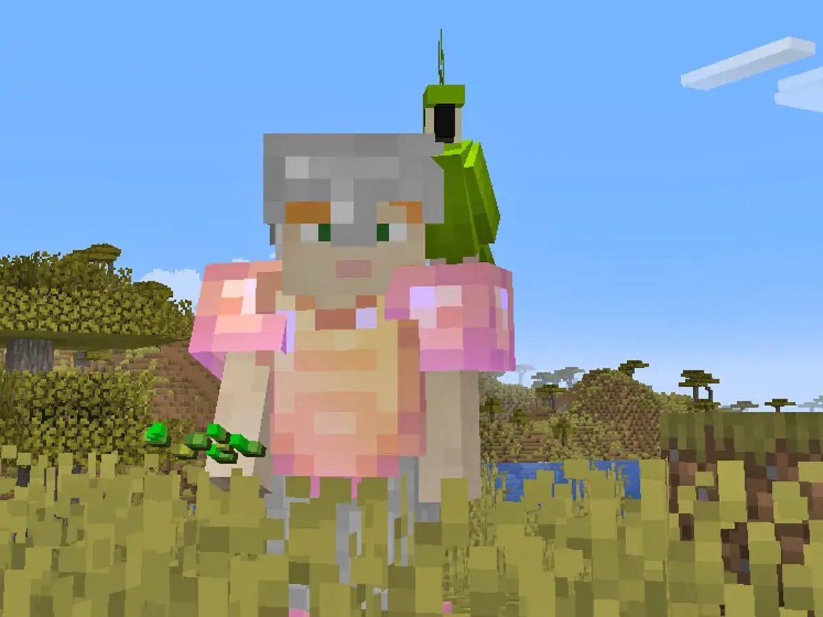 Gracz w zbroi z papugą na ramieniu, trzymający nasiona. Dowiedz się, jak oswoić zwierzęta w Minecraft.