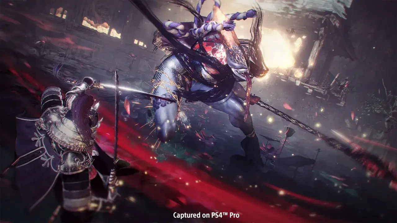 Nioh 2: Wojownik w zbroi walczy z potworem o niebieskiej skórze i długich włosach, otoczeni płatkami i czerwonymi smugami.
